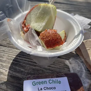a paper plate of food and a sign that reads green chile