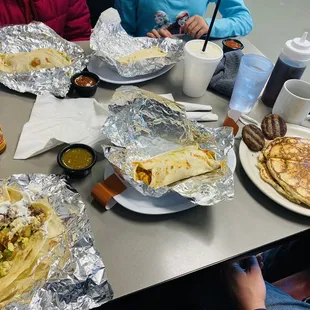 Three breakfast burritos, sausage, pancakes.
