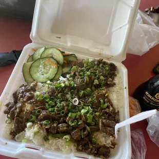a styrofoam container filled with rice and beef