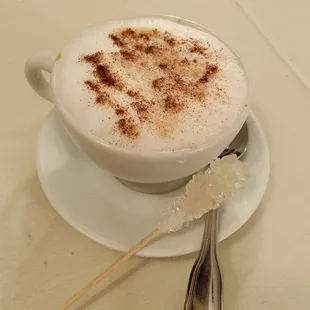 Cappuccino with sugar stick.