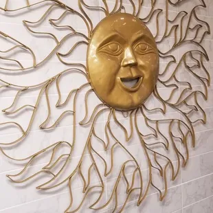 a gold sun face on a wall