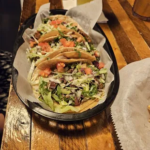 a tray of tacos and a glass of beer