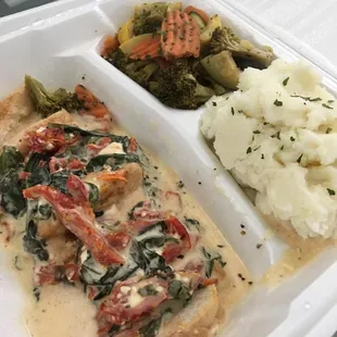 Tuscan chicken with creamy mashed potatoes and roasted veggies.