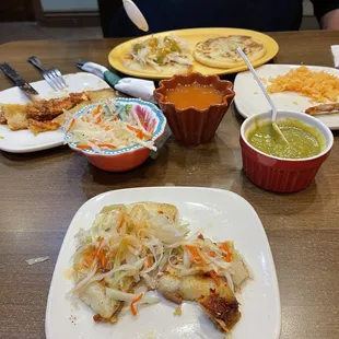 Half eaten bean and cheese pupusas in front   Then slaw, sauces - Spicey but great touch!