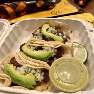 three tacos in a styrofoam container