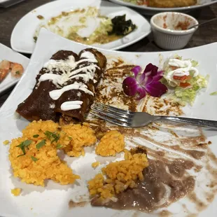Enchiladas con mole, arroz y frijoles.