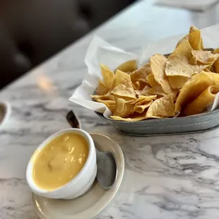 a bowl of chips and a bowl of sauce