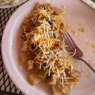 Papitas with green chiles, red sauce, salsa, and cheese on top!