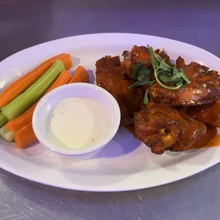 a plate of chicken wings and carrots