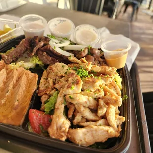 Fresh green salad with tasty chicken and beef with spicy hummus that's actually spicy