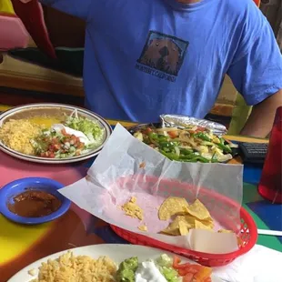 a man sitting at a table with plates of food