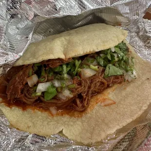 Corn tortilla with shredded beef made with red sauce.
