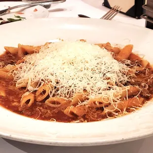 Penne with Bolognese meat sauce topped with shredded parmesan cheese