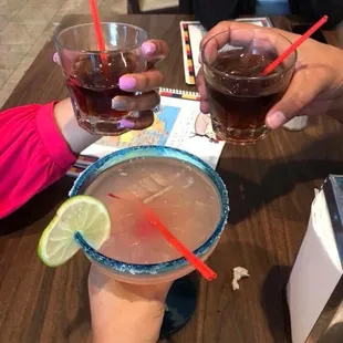 two people clinking glasses of drinks