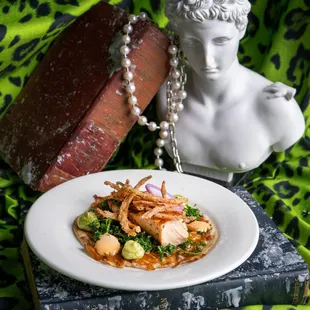 a plate of food with a statue in the background