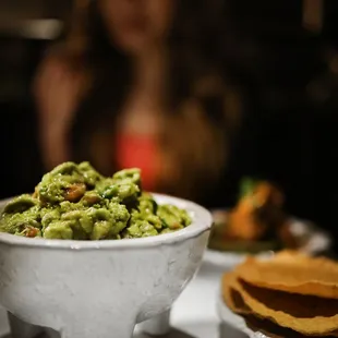 a bowl of guacamole and tortillas