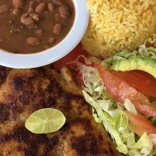 Milanesa de Pollo (chicken breast lightly breaded) with rice and charro beans