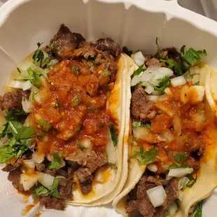 two tacos in a styrofoam container
