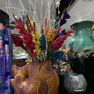 a vase with flowers and a fish