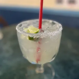 a margarita in a glass with a red straw