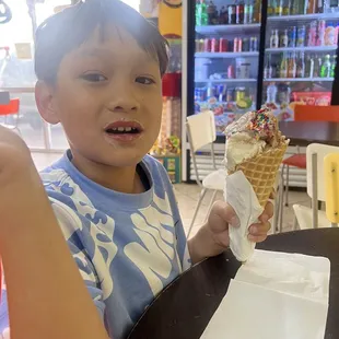 Large cone with gummy flavored ice cream, chocolate ice cream, and sprinkles