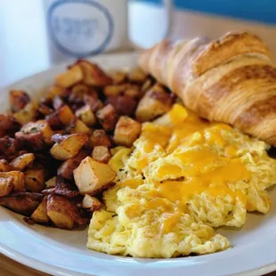 Scrambled eggs with cheese and home fries.