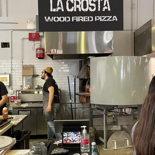 Friendly staff by the sign and the pizza oven. He immediately posed after, but I respect staff privacy so going with this one.