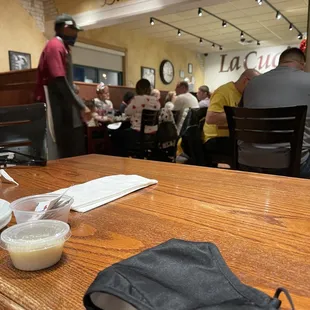 a wooden table with a napkin, fork and spoon on it