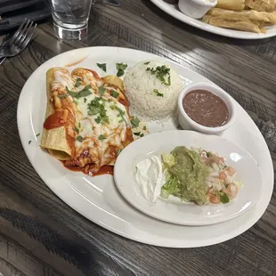 Shrimp enchiladas, cilantro rice, beans, and toppings.