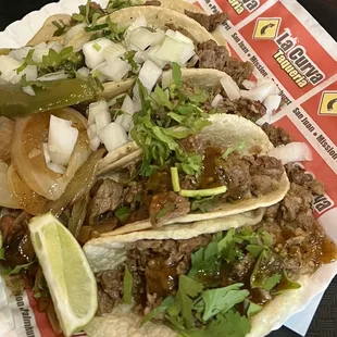 Tacos with Ryan cilantro grill jalapeños lemon wedges red and green salsa corn tortilla.