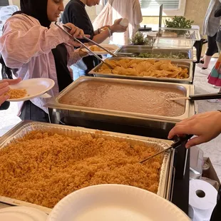 people serving themselves at a buffet