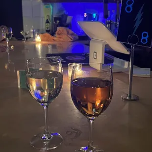 two glasses of wine on a bar