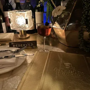 a table setting with a menu and wine glasses