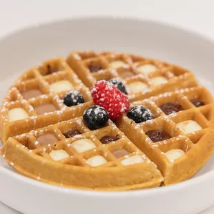 a waffle with berries and powdered sugar