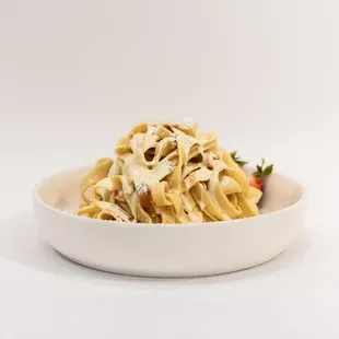 a bowl of pasta and a strawberry