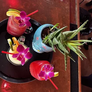 three cocktails on a black plate