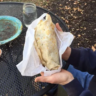 a person holding a burrito