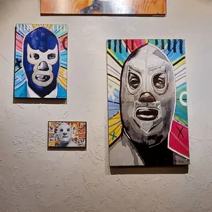 a wall with paintings of luchas