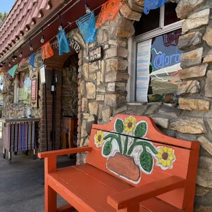 a red bench in front of a store