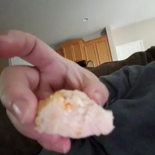 a person holding a half eaten doughnut