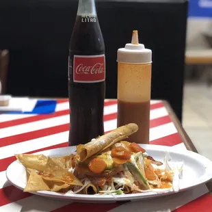  a plate of nachos and a bottle of coke