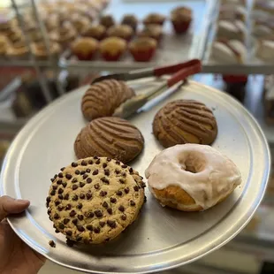 a person holding a plate of doughnuts