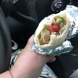 a hand holding a burrito