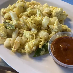a plate of scrambled eggs and sauce