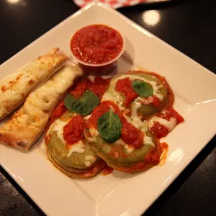 Jumbo spinach Ravioli with cheese sticks and marinara sauce on the side.