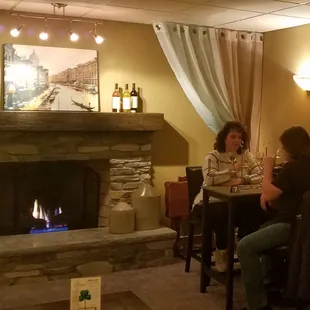 Customers enjoying some wine near the fireplace