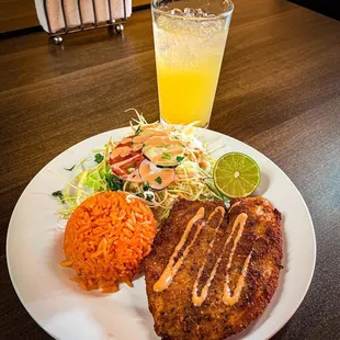 a delicious breaded tilapia fillet accompanied by delicious rings and salad