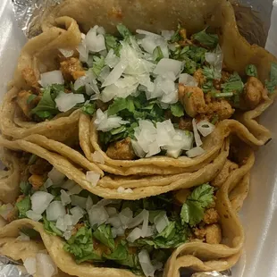 Two chicken and chorizo tacos with onion and cilantro