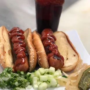 two hot dogs with ketchup and pickles
