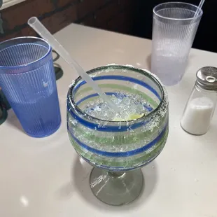 Large Margarita with dirty blue glass in background